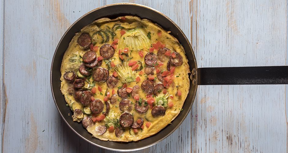 Greek frutalia omelet with zucchini blossoms and sausages
